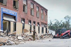 Airmen from the 159th Civil Engineering’s Debris Clearance Package clear rubble from a roadway in downtown Lake Charles, La., Aug. 30, 2020. The Louisiana Air National Guard Airmen arrived with heavy equipment shortly after Hurricane Laura’s landfall to clear roadways of the hardest hit areas in and round Calcasieu Parish, La. (The National Guard, CC BY 2.0, via Wikimedia Commons)