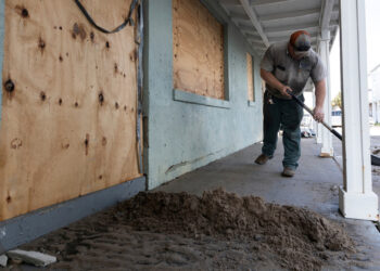 Matt Suggs shovels mud outside the old Nature Coast Biological Station lab following Hurricane Idalia. (Tyler Jones, UF/IFAS)