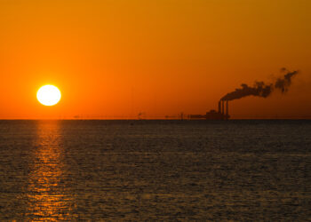 The sun rises as a power plant emits smoke near St. Petersburg (iStock image)