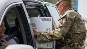 Florida Army National Guard Staff Sgt. Martin Martinez distributes food in Bradenton to assist the local community Oct. 11 following Hurricane Milton. (U.S. Army photo by Sgt. Marc Morgenstern, via Defense Visual Information Distribution Service)