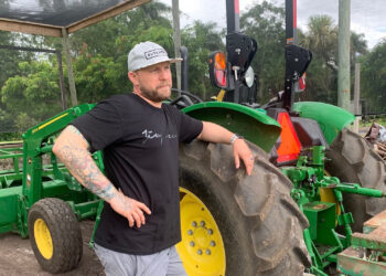 Jeremy Ford stands near a tractor with automation. (Ayurella Horn-Muller/Grist)
