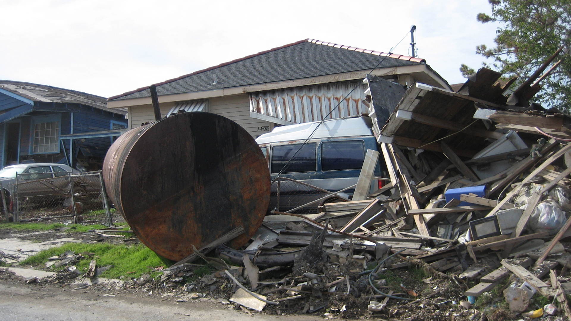A storage tank deposited on residential street by flood waters in New Orleans after Hurricane Katrina. (Infrogmation, CC BY 2.5, via Wikimedia Commons)