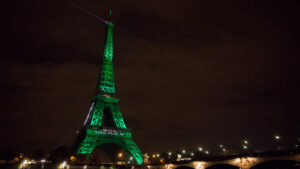 The Eiffel Tower is illuminated in green to celebrate the Paris Agreement in 2016. (Jean-Baptiste Gurliat via the U.S. Embassy Paris, Public domain, via Wikimedia Commons)