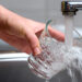 Water pours from a faucet into a glass (iStock image)
