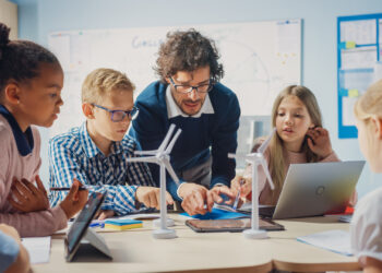 A teacher explains to students how wind turbines work. (iStock image)