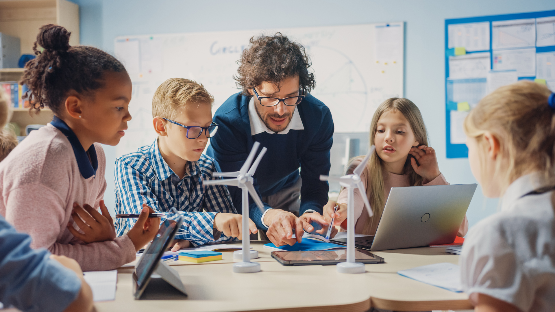 A teacher explains to students how wind turbines work. (iStock image)