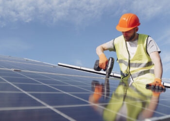 A worker installs solar panels (iStock image)