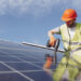 A worker installs solar panels (iStock image)
