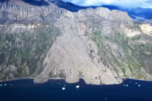 A massive rockslide, triggered by permafrost melt, tumbled down the fjord wall and into the water at Assapaat, West Greenland. (Kristian Svennevig/GEUS)