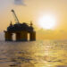 An offshore drilling platform at sunset in the Gulf (iStock image)