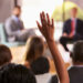 A woman raises her hand to ask a question (iStock image)