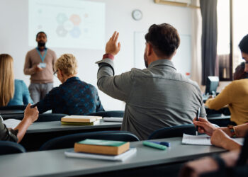 A student raises his hand in a classroom (iStock image)