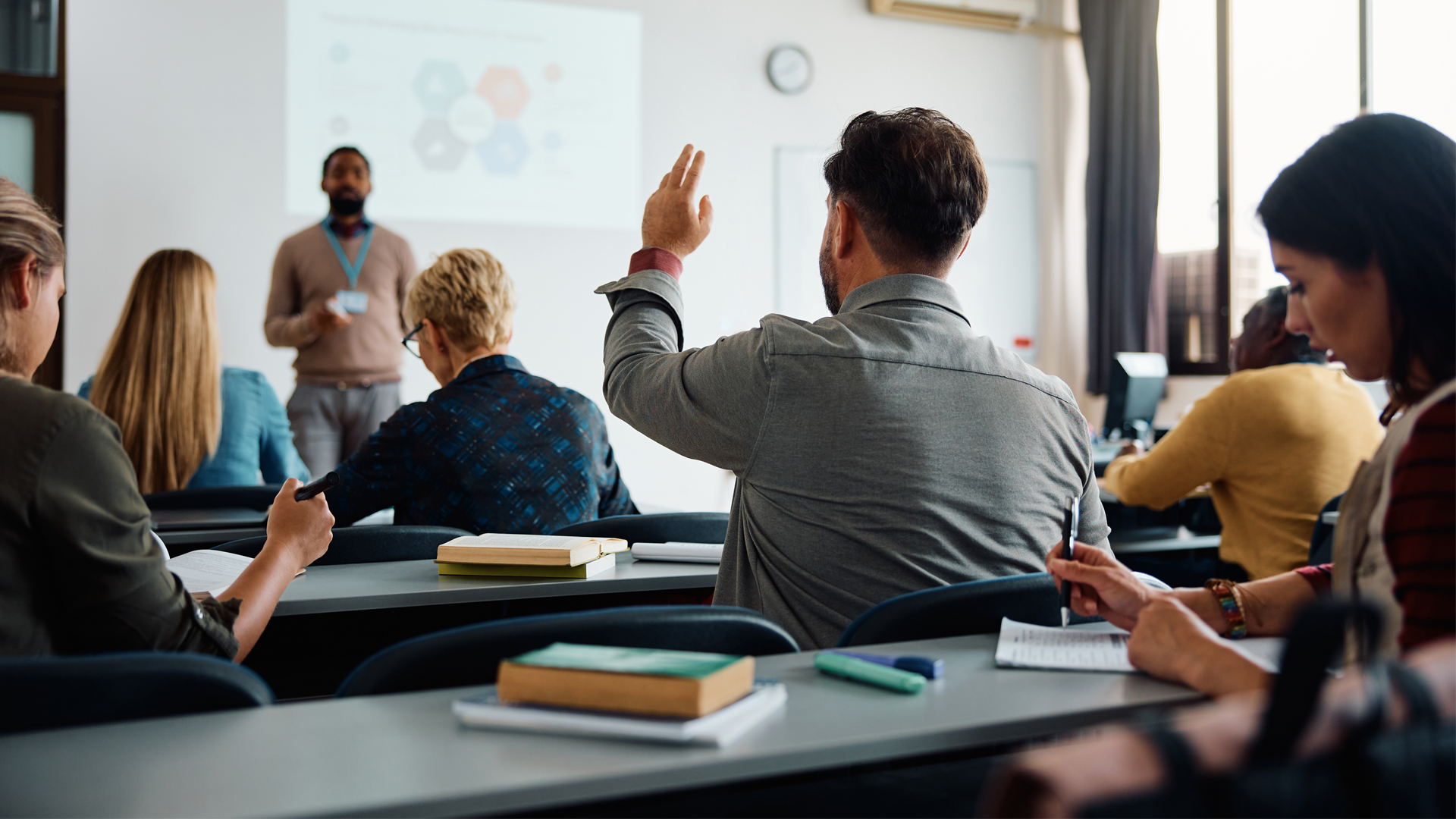 A student raises his hand in a classroom (iStock image)