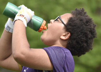 A youth football player hydrating (iStock image)