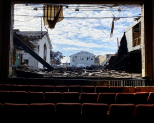 The destruction from the Dec. 10, 2021, tornadoes in Mayfield, Kentucky, as seen through a wall that was destroyed in the American Legion theater. (Jocelyn Augustino/FEMA, via Defense Visual Information Distribution Service)