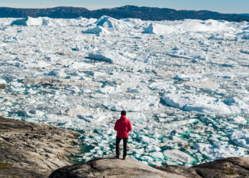 A man looks at melting ice in Greenland (iStock image)