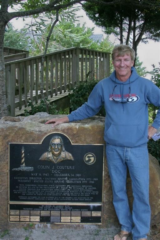 Tom Warnke at a historical marker recognizing Colin “Doc” Couture, the late director of the Eastern Surfing Association who is the namesake of a volunteer award that Warnke received in 2009. (Photo courtesy of Tom Warnke)