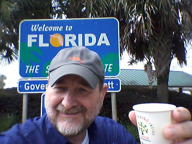 Craig Pittman holds a cup of orange juice at the Florida state line (Photo courtesy of Craig Pittman)