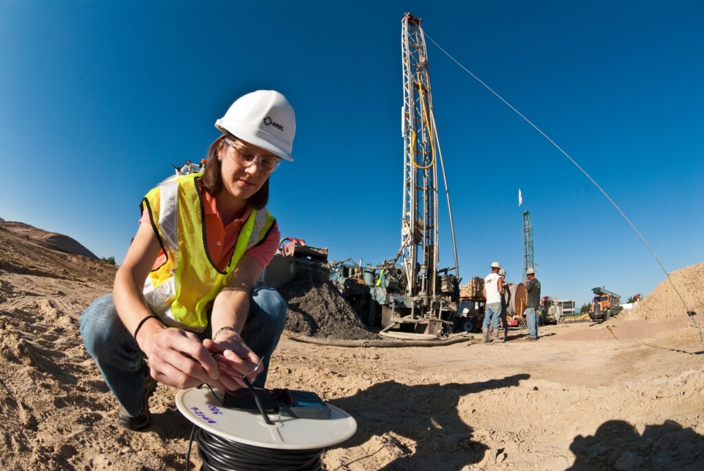 National Renewable Energy Laboratory senior geothermal analyst Erin Anderson examines a heat sensor to make sure it's in working order before the wire attached to the sensor descends 500 feet under the IKEA store construction site in 2010 in Centennial, Colo. (Pat Corkery/National Renewable Energy Laboratory)