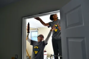 Two members of AmeriCorps install a door frame in a house damaged by Hurricane Sandy in Brooklyn, New York. (Jewel Samad/AFP, Getty Images via Grist)