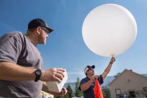 A meteorologist prepares to launch a weather balloon at Mammoth Hot Springs, Wyo. Data collected by the balloon’s radiosonde will help predict local weather that can influence fire behavior. (Neal Herbert/National Park Service)