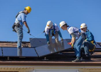 Staff from the National Renewable Energy Laboratory and GRID Alternatives Colorado install rooftop solar panels during a 2023 volunteer event with GRID Alternatives Colorado. The 6.7-kilowatt solar installation project should provide the home with $1,200 annual savings over the next 20 years. (Joe DelNero/National Renewable Energy Laboratory)