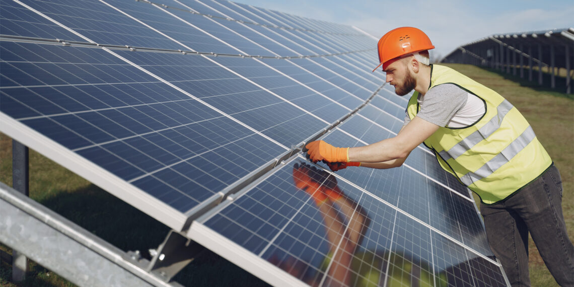 A worker adjusts solar panels (iStock image)