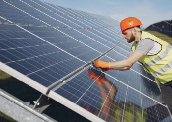 A worker adjusts solar panels (iStock image)