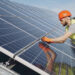 A worker adjusts solar panels (iStock image)