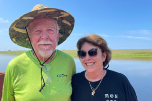 When it’s not too hot, Steve Cates and his fiancée, Marie Shoffeitt, like to sit on the dock behind his house and watch boats go by on a canal leading directly to Lake Okeechobee. Insurance has been a struggle for them both. (Credit: Amy Green/Inside Climate News)