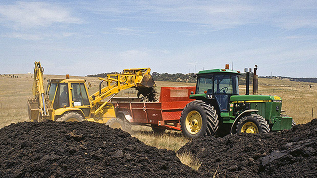 Biosolids being loaded into a spreader (CC BY-NC-SA 2.0, via flickr)