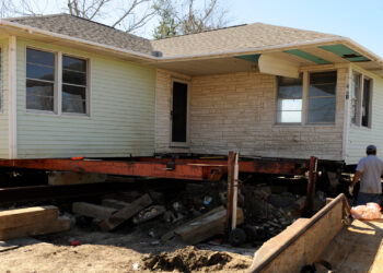 A home being raised to prevent future flooding (Mike Moore, Public domain, via Wikimedia Commons)