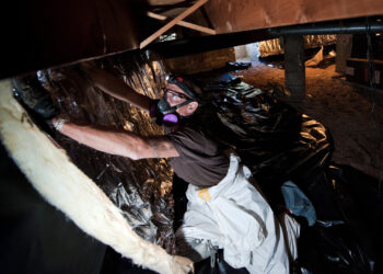 A worker with Veterans Green Jobs puts insulation into the crawl space of a home as part of the Energy Department's Weatherization Assistance Program. (U.S. Department of Energy, Public domain, via Wikimedia Commons)