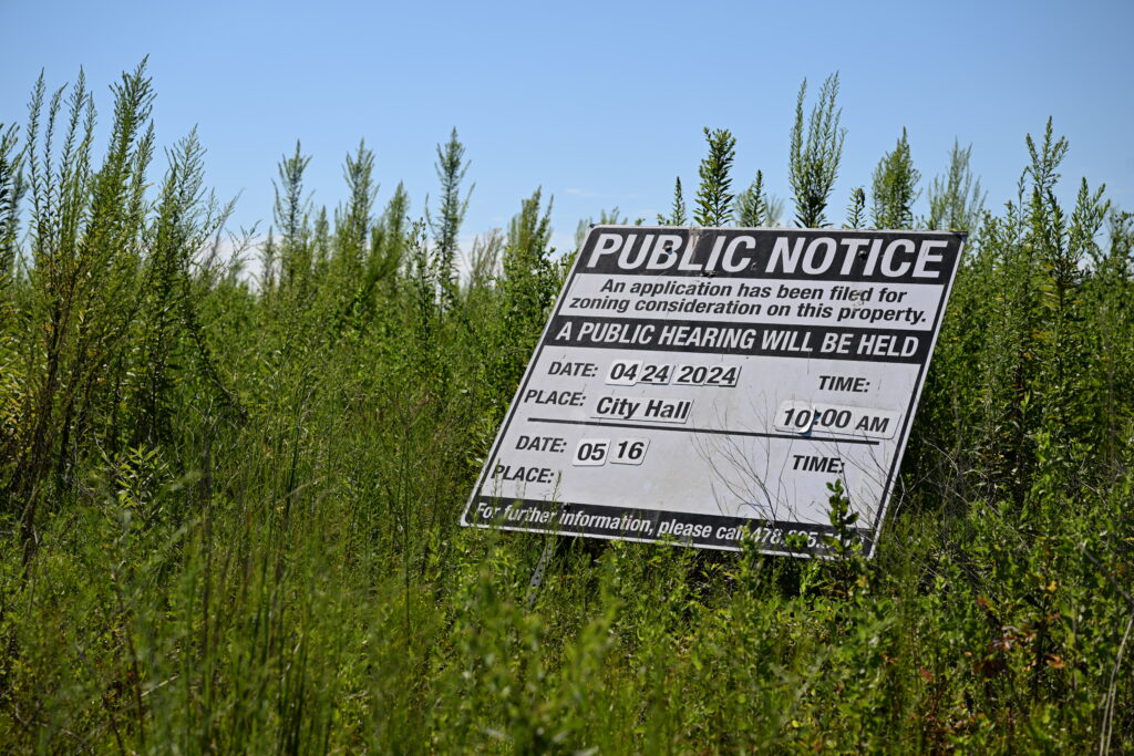 A public notice for zoning consideration sits off of Julius C Simmons Avenue in Fort Valley, Ga. on Sept. 2, 2025. More than 130 acres of land are proposed as the site of an electric vehicle plant that Imola hopes to build. (Katie Tucker/Macon Telegraph)