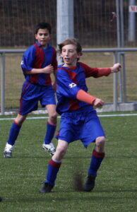 Granulated rubber made from recycled car tires is kicked up from the artificial turf on a soccer field (Usien, CC BY-SA 3.0, via Wikimedia Commons)