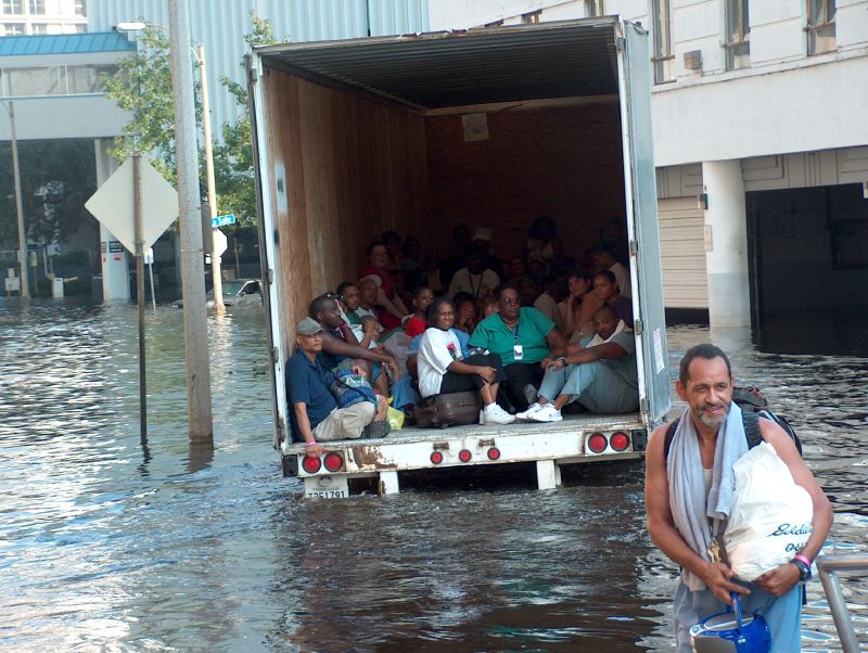 A charity’s truck evacuates New Orleans residents through flood waters after the Hurricane Katrina levee failure disaster in 2005. (Ben Record, CC BY-SA 2.0, via Wikimedia Commons)