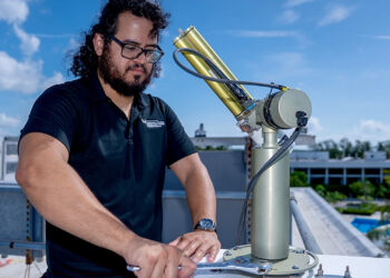Doctoral student Michael Perez tends to the sun photometer on the roof of a building at the Marine Campus. (Photo: Matthew Rembold/University of Miami)