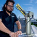 Doctoral student Michael Perez tends to the sun photometer on the roof of a building at the Marine Campus. (Photo: Matthew Rembold/University of Miami)