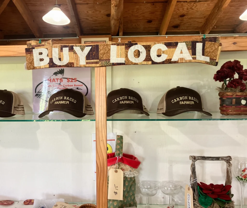 “Buy Local” reads a sign in Crone’s Cradle Conserve’s country store. Guinn, who manages the property, loves the hats. (Credit: Tarryn Nichols)
