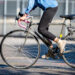 A woman rides a bike on city street. (iStock image)