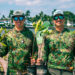 Keith and Kyle Rossin wear mangrove camouflage while holding mangroves for planting. (Photo courtesy of MANG)