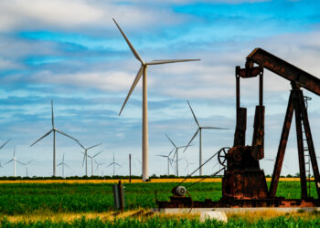 An aging oil pumpjack surrounded by wind turbines in West Texas (iStock image)