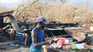 A man makes himself a small meal as he endures the impact of Hurricane Melissa. (World Central Kitchen, CC BY 4.0, via flickr)
