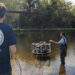 Jordon Beckler, Ph.D., and Mason Thackston (in the water) test their new device, the Chamber ARray for Observing Sediment Exchanges Long-term or CAROSEL for short. (FAU)