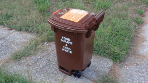 A brown trash bin distributed by the New York City Department of Sanitation for compostable waste such as food scraps and yard waste. (Tdorante10, CC BY-SA 4.0, via Wikimedia Commons)