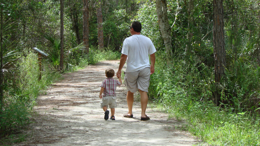 A father and son hike on a nature trail (iStock image)