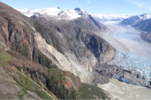 An aerial photo shows the result of an Aug. 10, 2025, landslide at South Sawyer Glacier in Alaska. The light-colored area of the mountainside is where the slide occurred. (USGS)