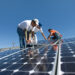 Workers install solar panels on a rooftop (iStock image)
