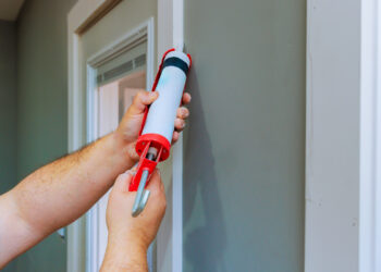 Putting caulking around doors is among the ways to weatherize a home and improve energy efficiency. (iStock image)