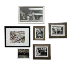 A gallery wall in Sam Cobb’s office illustrates his life’s story, from his relatives in the meat industry (top), to his college education in animal science (right), to the factory and employees of RMS Foods (left). (Frida Garza/Grist)